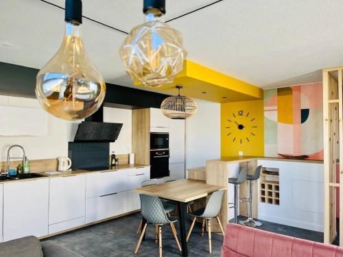 une cuisine avec une table et des chaises dans une pièce dans l'établissement La Calypso Jolie T3 Vue Mer Terrasse Parking Wifi, à La Rochelle