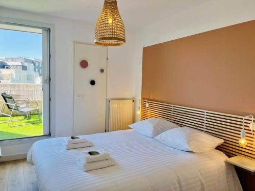 une chambre avec un grand lit avec deux serviettes dessus dans l'établissement La Calypso Jolie T3 Vue Mer Terrasse Parking Wifi, à La Rochelle