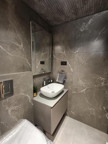 a bathroom with a sink and a mirror at Long Wood Hills Cottage in Ooty