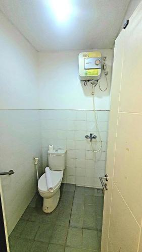a small bathroom with a toilet and a television at RAM Homestay Sharia, 5 Adults 1 Child, Ideal Stay Between Bromo & South Malang Beaches in Bareng