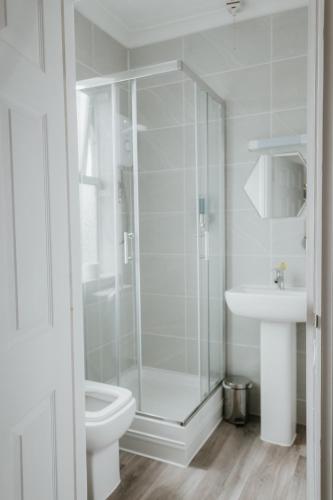 a bathroom with a shower and a toilet and a sink at Hayward's at the Grasmere in Keynsham