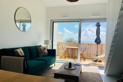 un salon avec un canapé vert et une table dans l'établissement La Canopee - Beau T3 Vue Mer Imprenable, à La Rochelle