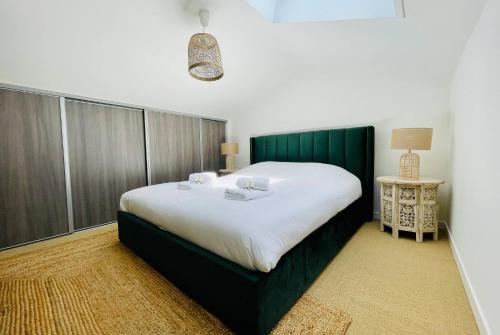 une chambre avec un grand lit avec une tête de lit verte dans l'établissement La Canopee - Beau T3 Vue Mer Imprenable, à La Rochelle