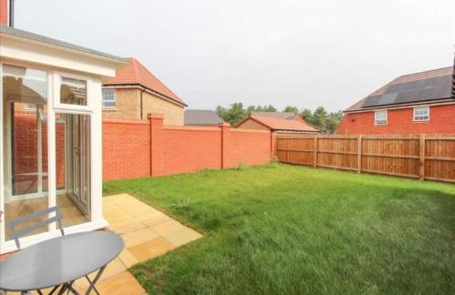 a backyard with a lawn and a fence at House-Sleeps 8-Parking-Garden-Country Surroundings in Kettering