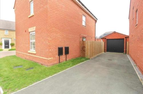 an empty parking lot next to a brick building at House-Sleeps 8-Parking-Garden-Country Surroundings in Kettering