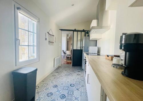 une cuisine avec un comptoir et un réfrigérateur dans l'établissement Appartement de Standing - Le Henri Jeanne 1910, à La Rochelle