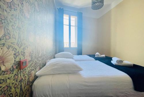 deux lits jumeaux dans une chambre avec fenêtre dans l'établissement Appartement de Standing - Le Henri Jeanne 1910, à La Rochelle