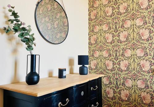 - une commode avec un miroir et un vase dans l'établissement Appartement de Standing - Le Henri Jeanne 1910, à La Rochelle