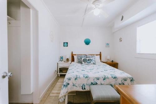a white bedroom with a bed and a window at NH337D Coastal Dunes 4 in Nags Head