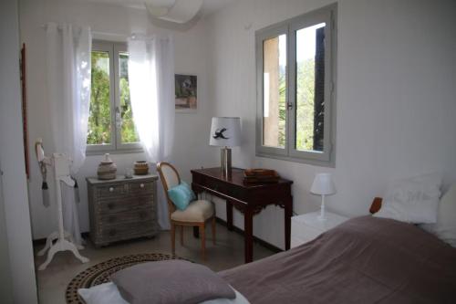 une chambre avec un lit, un bureau et des fenêtres dans l'établissement Petite maison de charme à la campagne, à Contes