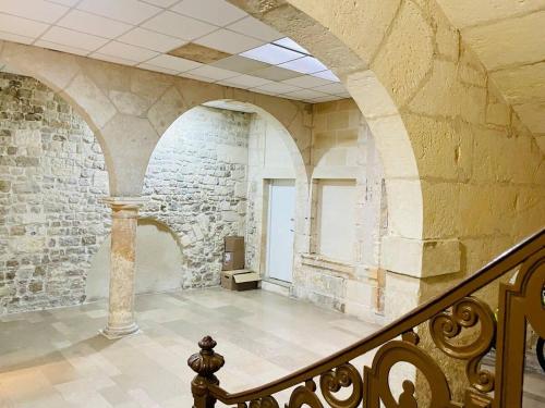 a staircase in an old building with a stone wall at Le Boudoir de Thais in La Rochelle