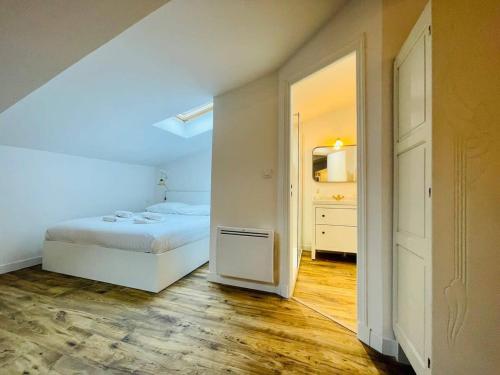 a bedroom with a white bed and a hallway at Le Boudoir de Thais in La Rochelle