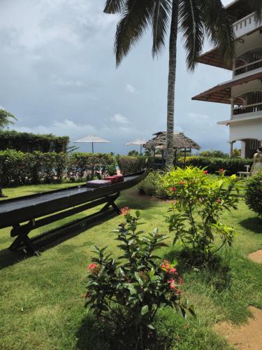a picnic table in the grass next to a building at Aadisaktthi Leisure Resort, Kovalam in Trivandrum