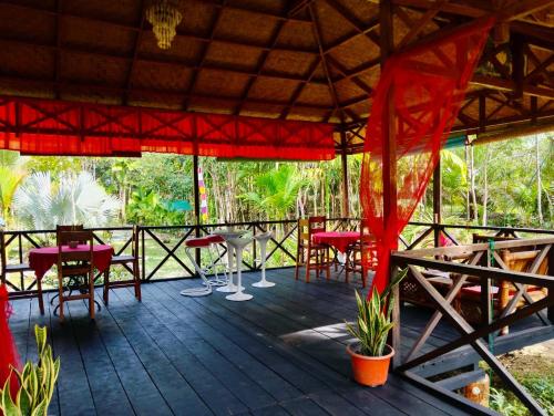 eine Terrasse mit roten Tischen und Stühlen darauf in der Unterkunft Bukit lawang in Bukit Lawang