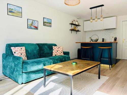 un salon avec un canapé bleu et une table dans l'établissement Le Flamant - Beau T2 avec Cour Privative, à La Rochelle