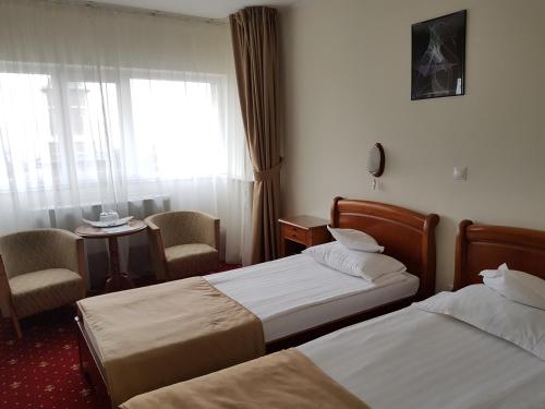 Una habitación de hotel con dos camas y una ventana. en Hotel Moldova, en Iaşi