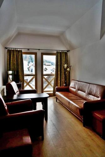 a living room with a couch and a table at Chata pod Pustą in Wierchomla Mała