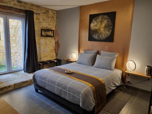 a bedroom with a bed and a large window at Le Clos de la Canéda in Sarlat-la-Canéda