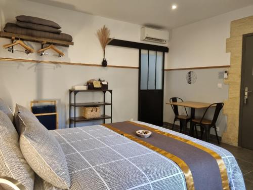a bedroom with a bed and a table with chairs at Le Clos de la Canéda in Sarlat-la-Canéda