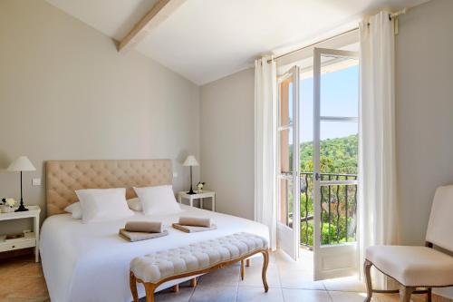 une chambre blanche avec un lit et un balcon dans l'établissement Residences Golf Club Saint-Tropez, à Saint-Tropez