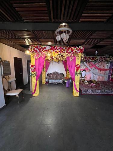 a room with a bed and a stage with flowers at Pond View By Basotel in Patna
