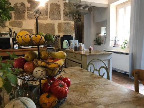 - une cuisine avec un bouquet de fruits et de légumes sur une table dans l'établissement Mas en pierres 17 couchages avec piscine et jardin, à Suze-la-Rousse