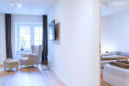 a living room with a chair and a bed at HITrental Zur Metzgern Apartments in Luzern