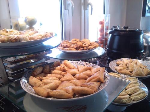 a table with several plates of food on a counter at Al Mandari Hôtel Tétouan in Tetouan