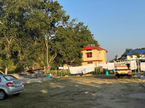 a car parked in a parking lot next to a house at Niribili Homestay in Majuli