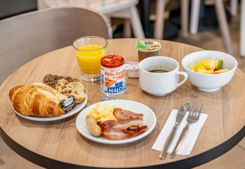 a table with two plates of breakfast food on it at B&B HOTEL Bordeaux Bassins à flot in Bordeaux