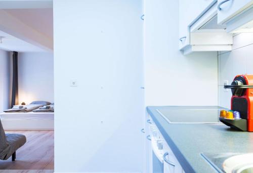 a kitchen with a counter with a sink and a stove at HITrental Zur Metzgern Apartments in Luzern