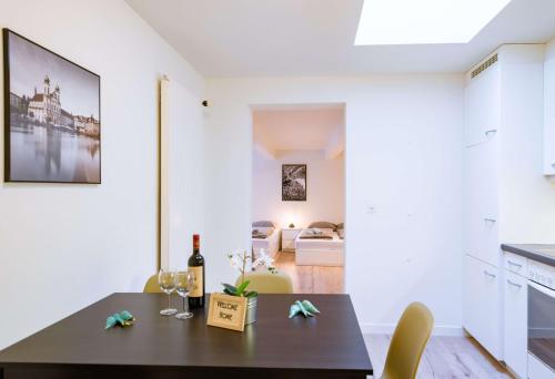 a kitchen and dining room with a table with a bottle of wine at HITrental Zur Metzgern Apartments in Luzern