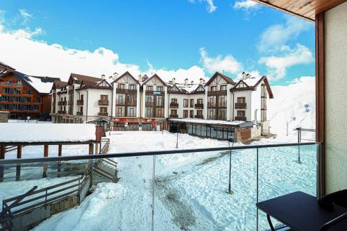 a view of a building in the snow from a balcony at Charming Studio Escape in Prime Ski Location in Gudauri