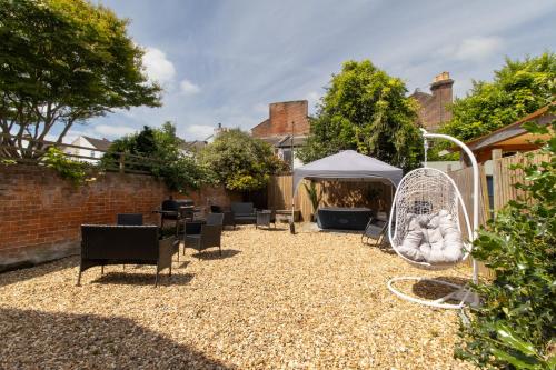 a backyard with a swing and a tent at Open Mind Property - HotTub, 8 Beds & 2 Car Spaces in Portsmouth