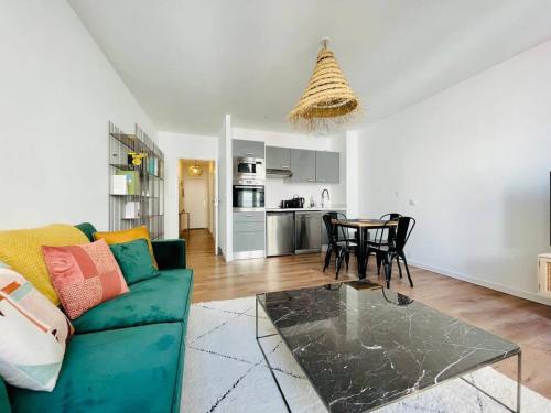 un salon avec un canapé vert et une table dans l'établissement Le Petit Minage - Charmant T2 Hypercentre - Wifi, à La Rochelle