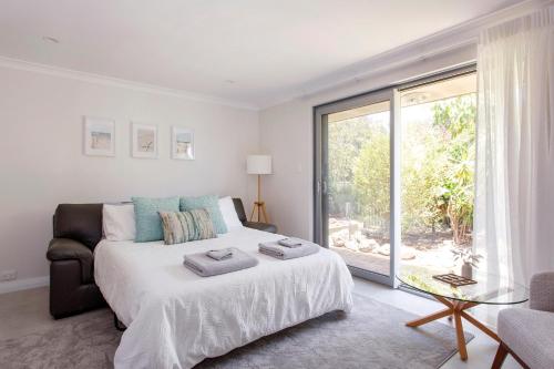 a bedroom with a bed and a large window at Maylands Riverside City Retreat in Perth