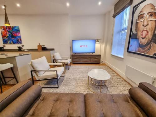 a living room with a couch and a flat screen tv at Luxury Altrincham Flat by City SuperHost in Altrincham