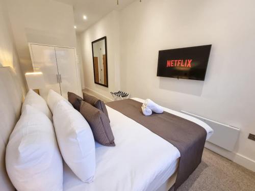 a bedroom with a large white bed with white pillows at Luxury Altrincham Flat by City SuperHost in Altrincham