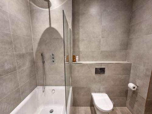 a bathroom with a shower and a toilet and a sink at Luxury Altrincham Apartment by City SuperHost in Altrincham
