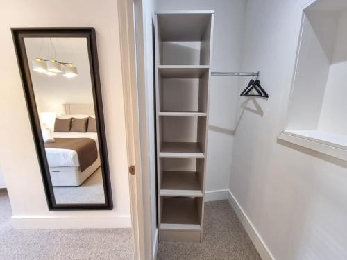 a bedroom with a mirror and a bed at Luxury Altrincham Apartment by City SuperHost in Altrincham