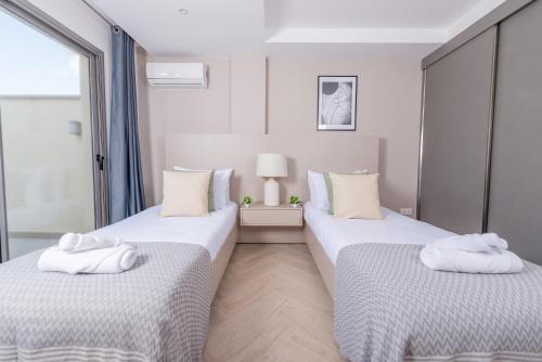 two beds in a room with white towels on them at Immense appartement 6pièces au Golf in El Mouradia