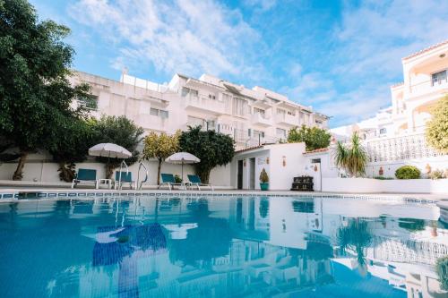 a swimming pool in front of a building at Apartamentos Julieta in Albufeira