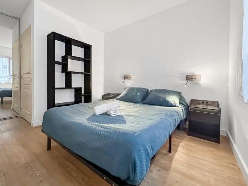 a bedroom with a large bed with a blue comforter at Balcon, parking, piscine et clim' à 2 pas du port Santa Lucia in Saint-Raphaël