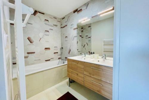 a bathroom with a tub and a sink and a shower at Le Cottage du Lac, centre ville, LR124 in La Rochelle