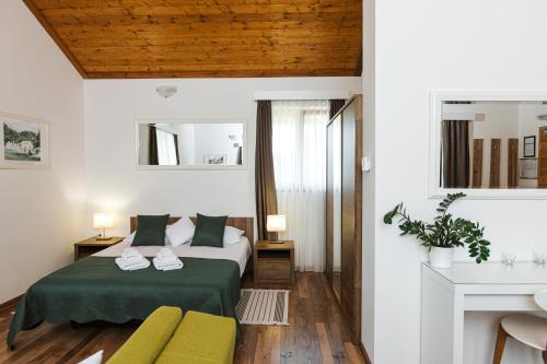 a bedroom with a green bed and a yellow couch at B&B Apartments Burić Plitvice Lakes in Plitvička Jezera