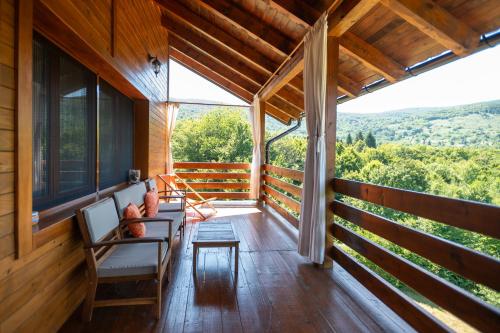 a porch of a cabin with chairs and a table at B&B Apartments Burić Plitvice Lakes in Plitvička Jezera