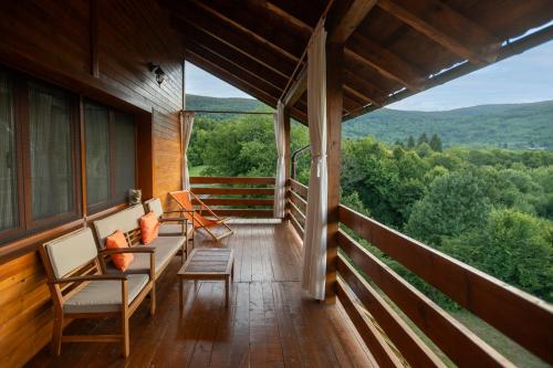 a porch of a cabin with a couch and chairs at B&B Apartments Burić Plitvice Lakes in Plitvička Jezera
