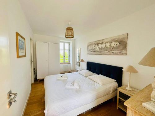 une chambre avec un grand lit blanc dans une pièce dans l'établissement La Chaloupe - Terrasse et Wifi, à La Rochelle