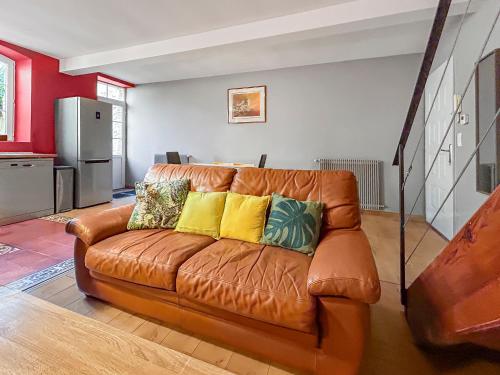 - un salon avec un canapé en cuir brun et des oreillers jaunes dans l'établissement T4 Centre Ville Grande Terrasse, à Agen