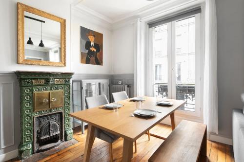 une salle à manger avec une table et une cheminée dans l'établissement T2 Spacieux à Paris 19e - Parc de la Villette, à Paris
